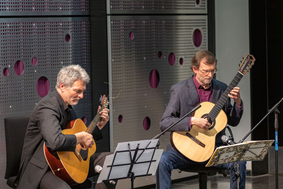 Prof. Dr. Georg Felser und Prof. Dr. Frieder Stolzenburg spielen Gitarre im AudiMax der Hochschule Harz