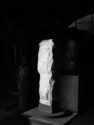Weiße Skulptur vor schwarzem Hintergrund