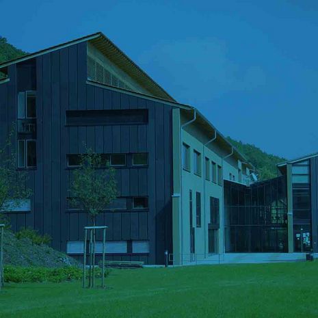 Symbolbild Virtuelle Thementage Hochschule Harz Forschung Modernes Gebäude vor Berglandschaft