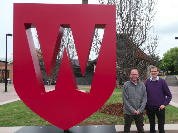 Zwei Männer vor dem Logo der Western Sydney University