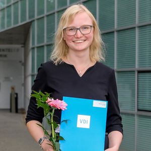 Melanie Stolze wurde vom Verein Deutscher Ingenieure für ihre Abschlussarbeit ausgezeichnet und hält eine Blume sowie eine Urkunde in den Händen.