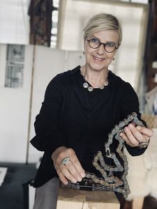 Anke Duda mit einem Ausstellungsstück. Eine alte Motorradkette wird nützlich, um das auszudrücken, was ihr durch den Kopf schießt. Foto: Britta Fuchs