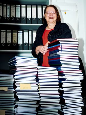 Sabine Elfring, Professorin für Betriebswirtschaftslehre, in ihrem Büro vor einem großen Stapel betreuter Abschlussarbeiten aus 46 Semestern.