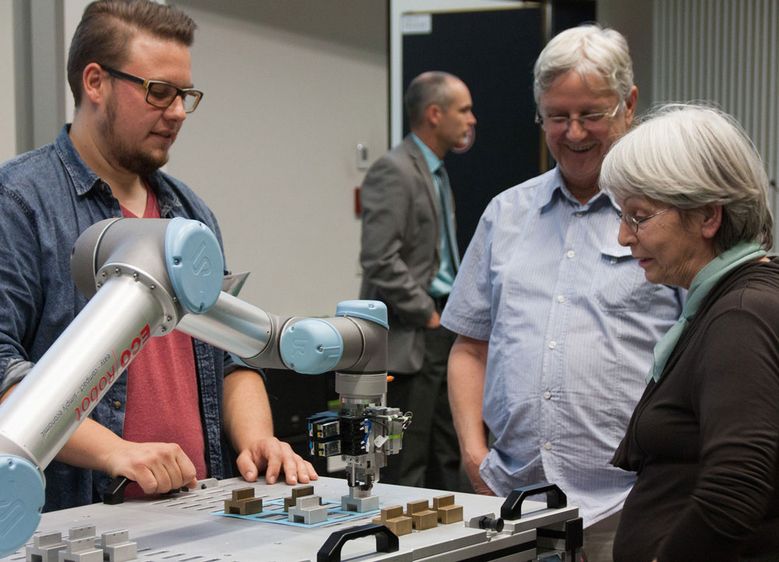 Bild: Zahlreiche Teilnehmerinnen und Teilnehmer der Oktober-Vorlesung der GenerationenHochschule ließen sich von Student Thys Witthöft die Funktionsweise des „TicTacToe“-Roboters des Fachbereichs Automatisierung und Informatik erklären.