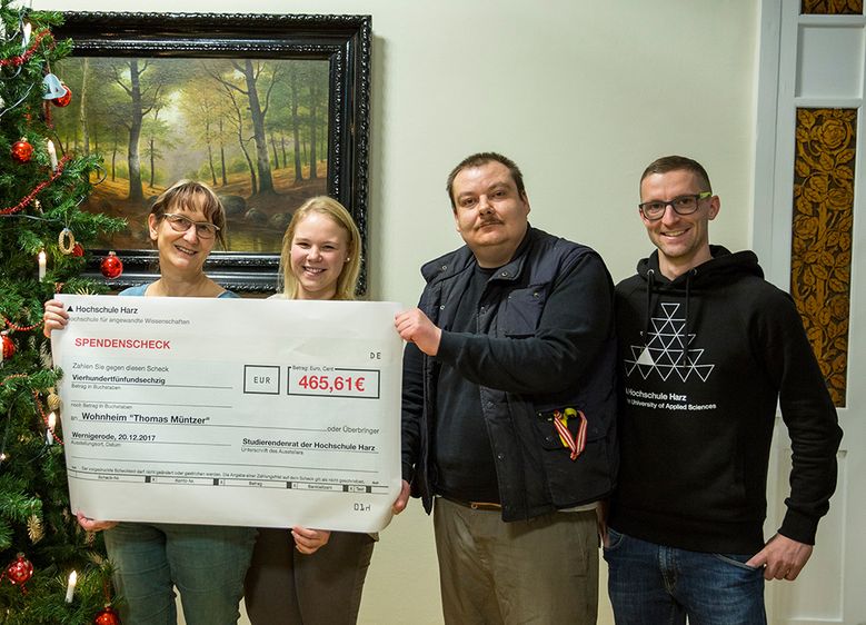 Wohnheim-Leiterin Birgit Tank, Jill-Cristin Krampf (Vorstandsmitglied des Studierendenrates), René Holland vom Bewohnerbeirat und Ilja Schicker (Studierendenrat) bei der Scheckübergabe im Rahmen der Weihnachtsfeier (v.l.n.r.). Foto Johannes Grünemeier 