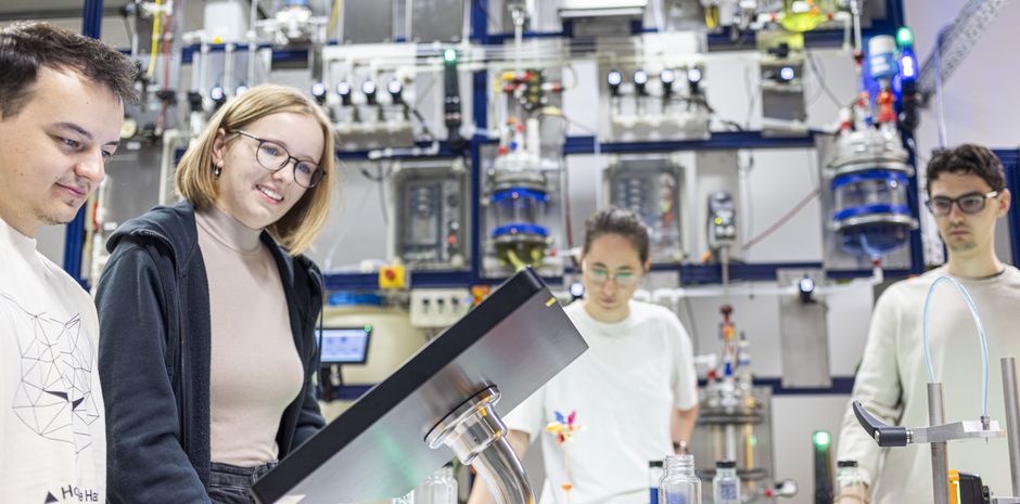 Studierende programmieren eine technische Anlage im Labor