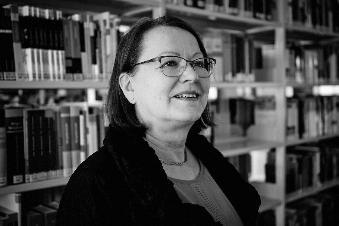 Porträt von Sabine Elfring vor einem Bücherregal in der Bibliothek der Hochschule Harz in Halberstadt