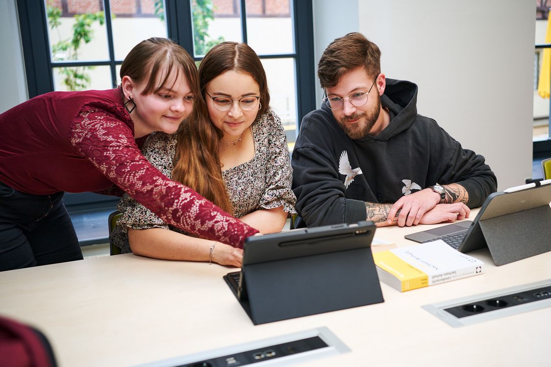 Drei Studierende der Verwaltungsökonomie in einem kleinen Lehrraum am Fachbereich Verwaltungswissenschaften der Hochschule Harz.