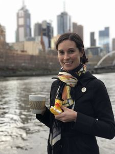 Nadine Schmidt lächelnd vor Skyline der australischen Metropole Melbourne.
