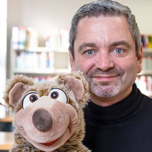 Pressebild zur Ankündigung der Kinderhochschule zum Thema Glück. Zu sehen sind Prof. Dr. André Niedostadek und Glücksbotschafter Kito.