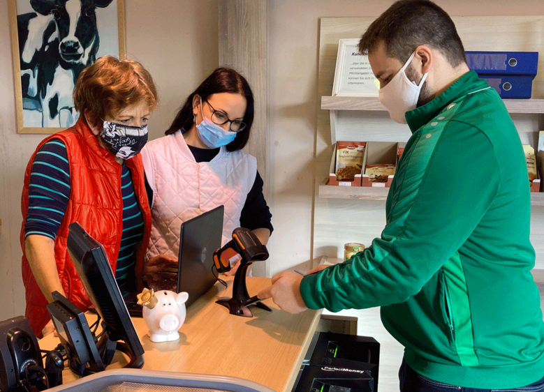  Hochschulmitarbeiter Oliver Otto zeigt Christel Wagner und Vasilica Niebling im Verkaufsraum der Schauener Landfleischerei, wie die Abholung von bestellten Waren ablaufen könnte 