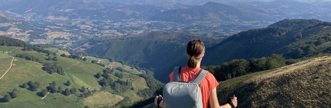 Frau mit Rucksack vor Gebirgslandschaft in Spanien