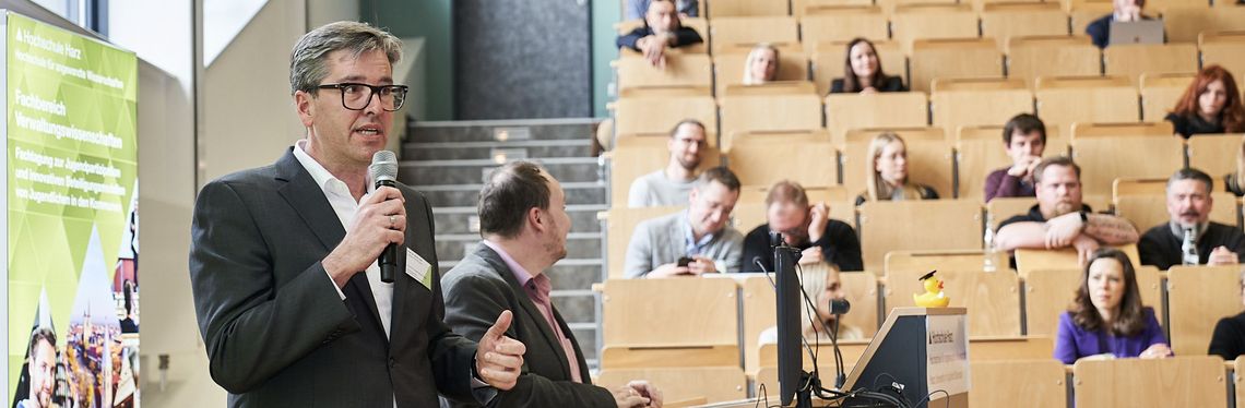 Bild von zwei Referenten vor Publikum im Hörsaal des Fachbereichs Verwaltungswissenschaften der Hochschule Harz