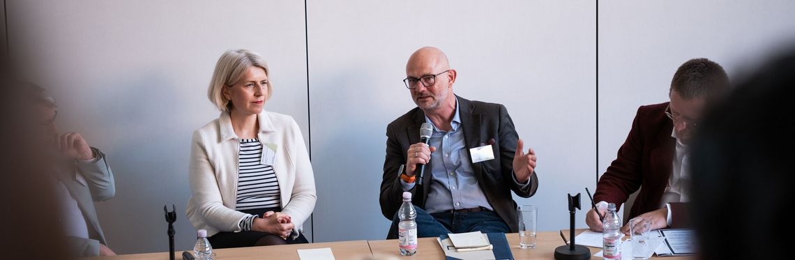 Zwei Redner während einer Podiumsdiskussion bei der WiföLab-Tagung 2026