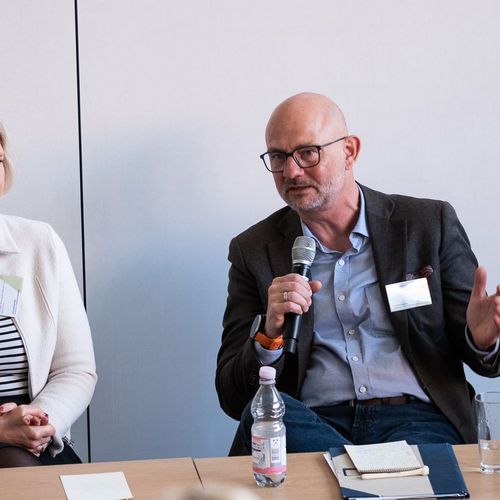 Zwei Redner während einer Podiumsdiskussion bei der WiföLab-Tagung 2026