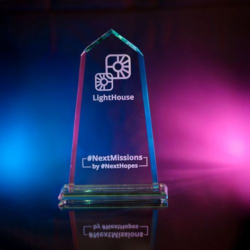 Tiffany-Preis-Trophäe für innovative Wirtschaftsförderung vor schwarzem Hintergrund mit roten und blauen Lichtflares im Hintergrund