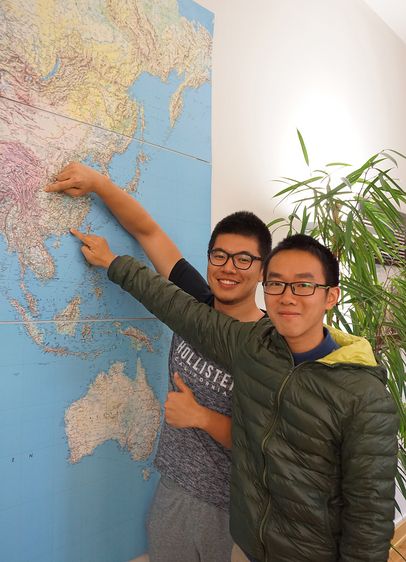 Die chinesischen Stipendiaten Huimin Zeng (links) und Hongjia Wan zeigen ihre Heimatorte auf der Weltkarte. Foto: Katharina Reif