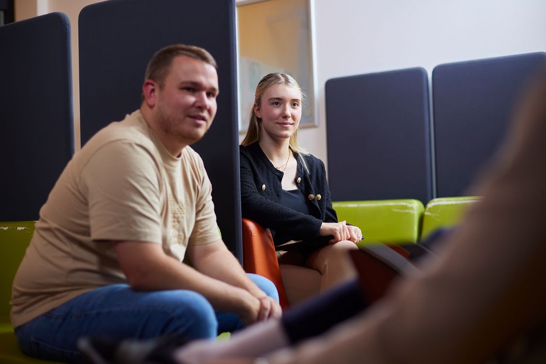 Zwei Studierende des Masterstudiengangs Digitale Verwaltung sitzen während einer Beratung in der Lounge des Fachbereichs Verwaltuingswissenschaften.
