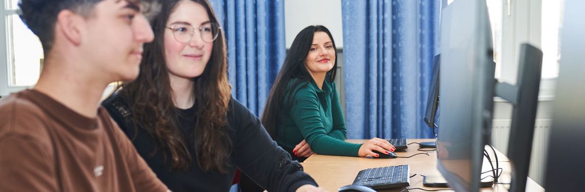 Drei Studierende des IT-Management – Verwaltungsinformatik vor digitalen Arbeitsplätzen in einem Labor an der Hochschule Harz.