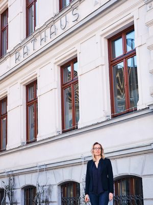 Franziska Wamsganß hat den Masterstudiengang Public Management abgeschlossen und steht hier vor der Fassade des Rathaus in Osterwieck.