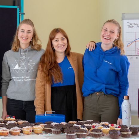 Frauen, Studentinnen lachend beim Muffin Verkauf