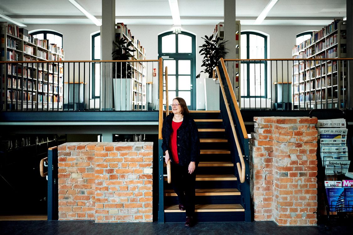 Sabine Elfring, Professorin für Betriebswirtschaftslehre, lehnt sich an ein Treppengeländer in der Bibliothek der Hochschule Harz in Halberstadt