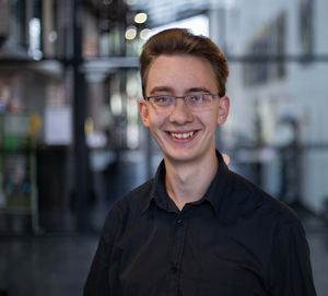 Junger Mann vor Glasfassade: Robert Boehm Absolvent der Hochschule Harz und Gründer