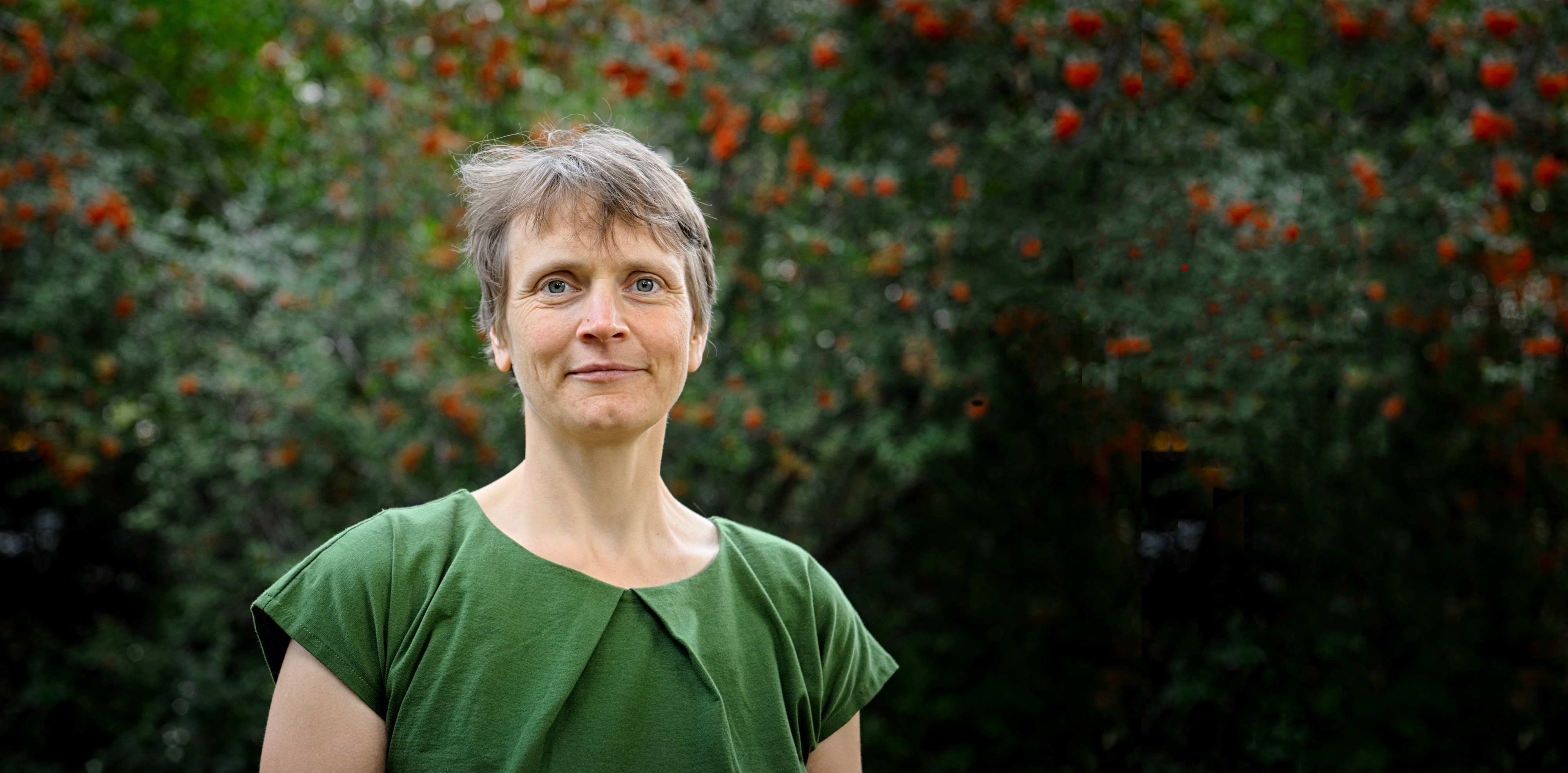 Frau vor Hintergrund mit Bäumen zeigt Prof. Alena Bleicher