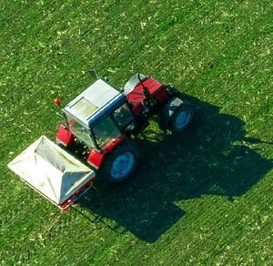 Symbolbild Digitalisierung Landwirtschaft: Traktor fährt über ein grünes Feld