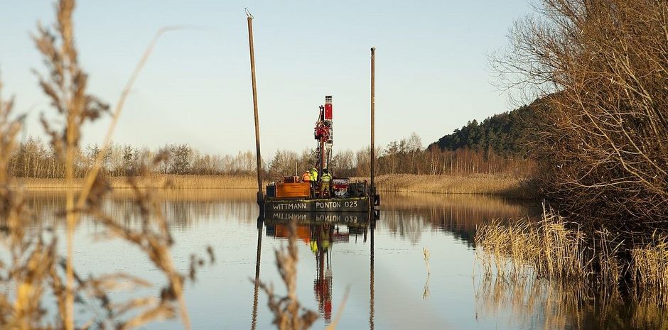 Ein Schiff auf einem See entnimmt Schlammprobe aus Bergeteich für Projekt Reminta an der Hochschule Harz